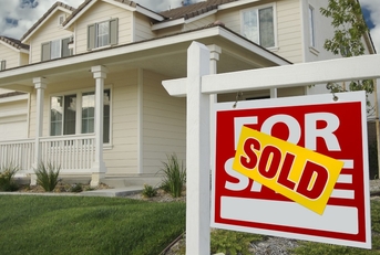 sold home for sale sign and house