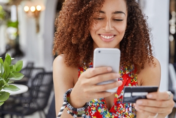 African American woman with credit card and phone
