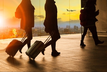 people and traveling luggage walking in airport terminal building