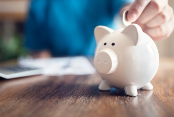 piggy bank with a coin placed in it