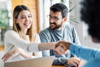 young couple shaking hands deal contract real estate investment