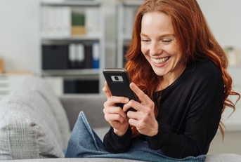 Smiling young woman using cellphone