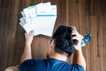 stressed young asian man hands holding the head 