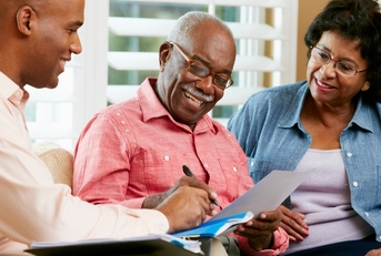 elderly man signing a document
