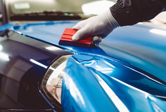 car wrapping specialist putting vinyl foil or film on car