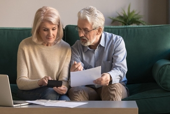 Serious mature couple calculating bills