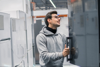 male customer choosing large fridges in domestic appliances section