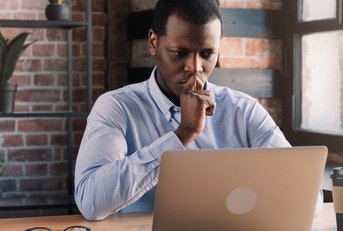 Man looking at computer and thinking