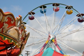 Fair carnival rides and tent top against blue sky