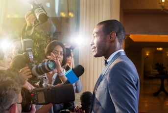 Celebrity being interviewed photographed by paparazzi at red carpet event