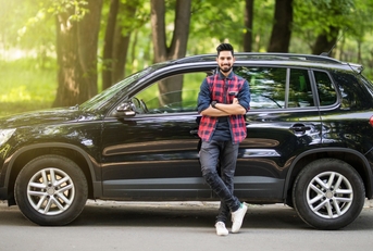 man standing in front of a black car