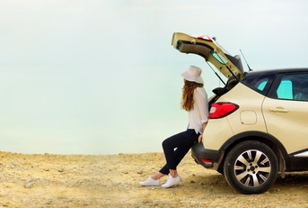 woman waiting by her car looking at an open space