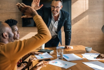two men high-fiving during a meeting
