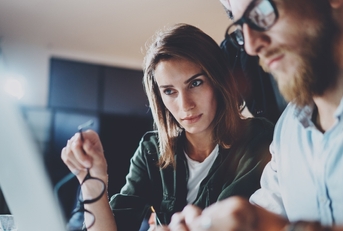 a man and a woman studying on a laptop
