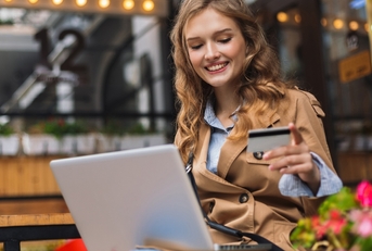a woman smiling while looking at a credit card