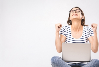 Happy woman sitting on floor with laptop