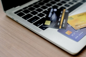 Three credit cards spread out on a laptop keyboard