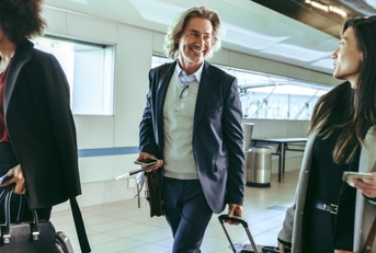 three travelers walking in an airport