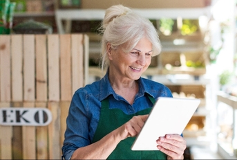 shop assistant with digital tablet in small grocery store