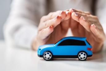 hands protecting a toy car