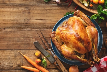 A roasted turkey on a wooden tabletop. 
