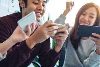 A group of people playing mobile games on their phones together. 