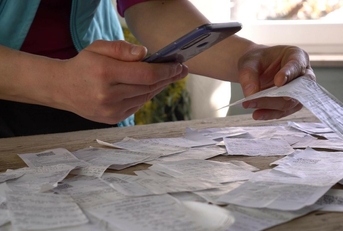 A person scans a paper receipt using their phone.