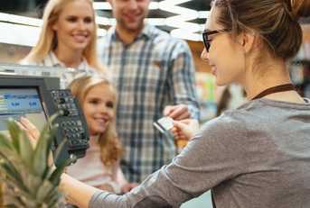 smiling family paying for their groceries