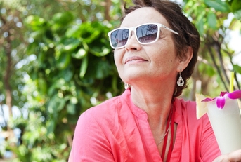 elderly woman in a hat with a cocktail in hand