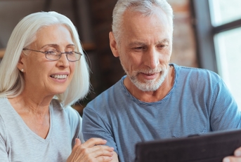 happy senior couple using tablet at home