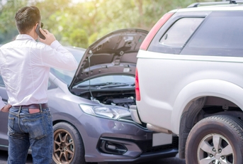 Man looking at wrecked car