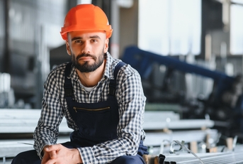 worker wearing uniform and hard hat in a steel factory