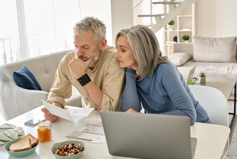 senior couple sitting on table reviewing documents