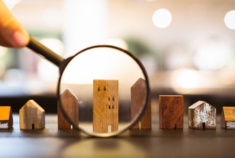 A magnifying glass inspecting small house models