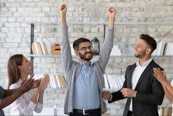 employees congratulating successful colleague with promotion