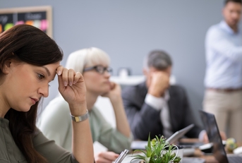 bunch of colleagues sad in presentation room at workplace