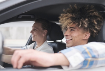 Two people driving a car after adding a driver to car insurance