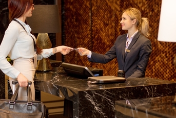 A tourist using her travel credit card at a hotel