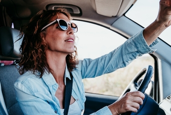 Woman adjusting rear-view mirror
