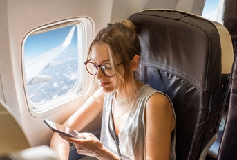 woman sitting with phone on the aircraft seat