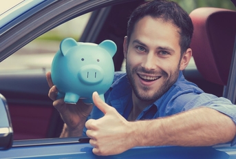 Man holding a piggy bank while riding a car