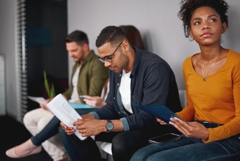 woman sitting in queue with other candidates for job interview