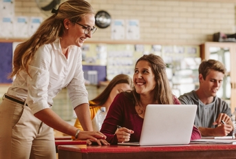 high school professor helping student in class