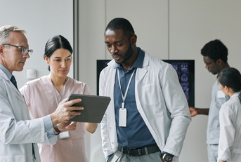 group of doctors looking at digital tablet