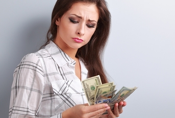 unhappy woman looking on dollars and thinking
