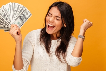 woman wearing white sweater screaming in excitement while holding money in hand in front of orange background