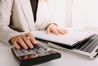 bookkeeper using calculator counting taxes fees