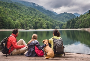 family having a vacation with their dog at mountainous area resting on pier together
