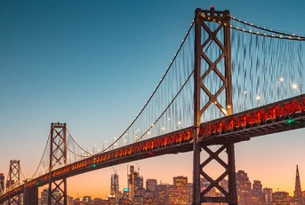 oakland bridge on water surrounding san francisco skyscrapers