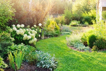 private garden with green plants everywhere along with english style cottage in corner